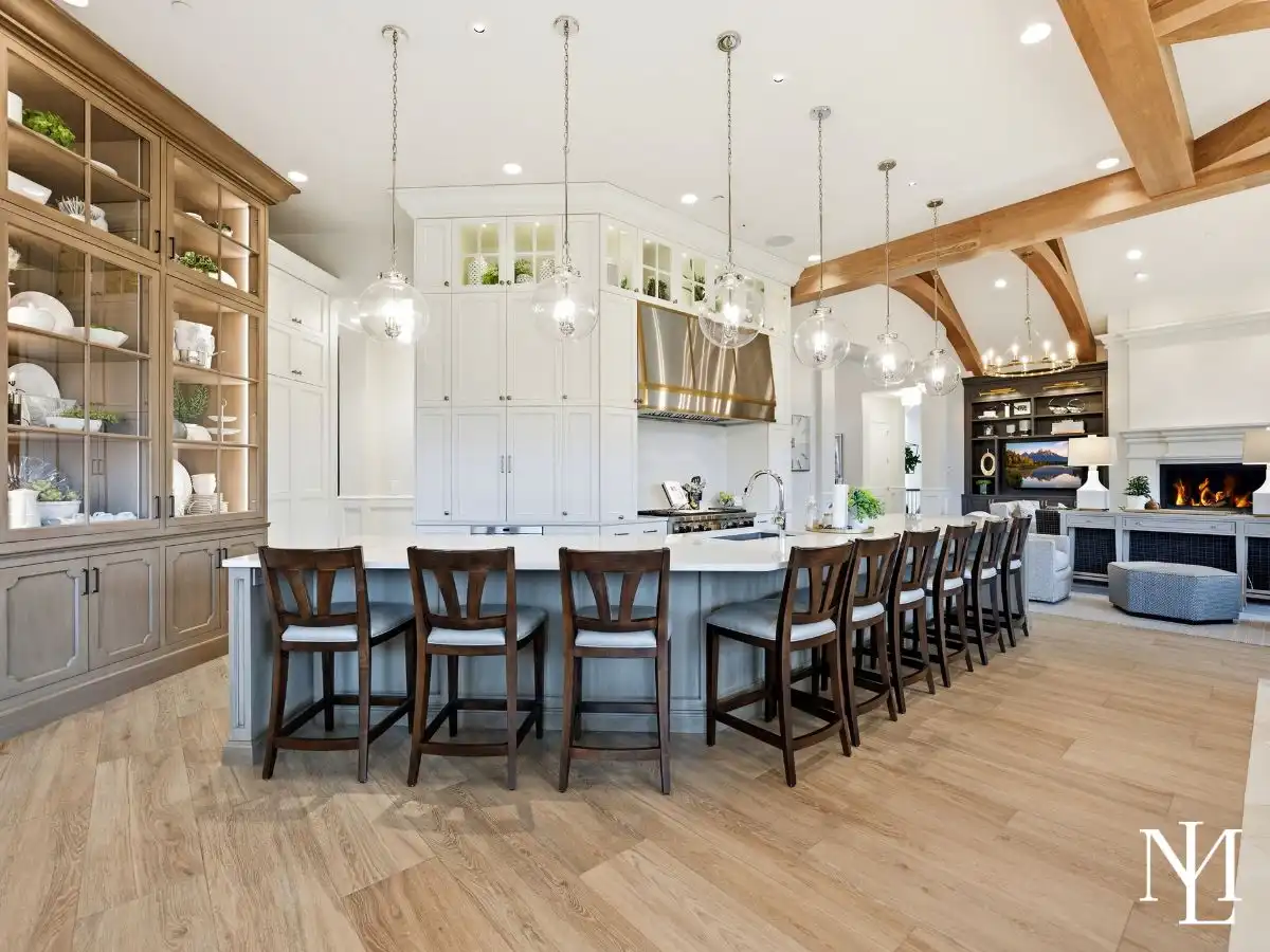 Oversized chef’s kitchen with long island seating, custom cabinetry, glass pendant lights, and open connection to great room.