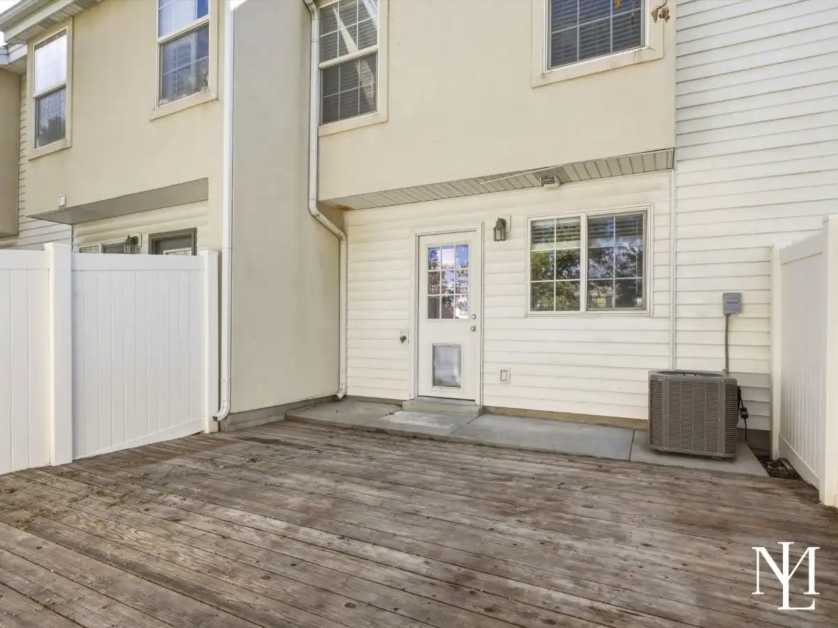 Private fenced patio at Draper townhome with wood deck, exterior access, and outdoor living space