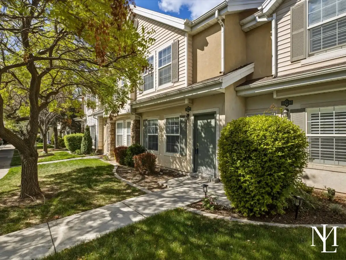 Exterior of Draper townhome near Corner Canyon with mature trees, landscaped walkway, and shaded front entry
