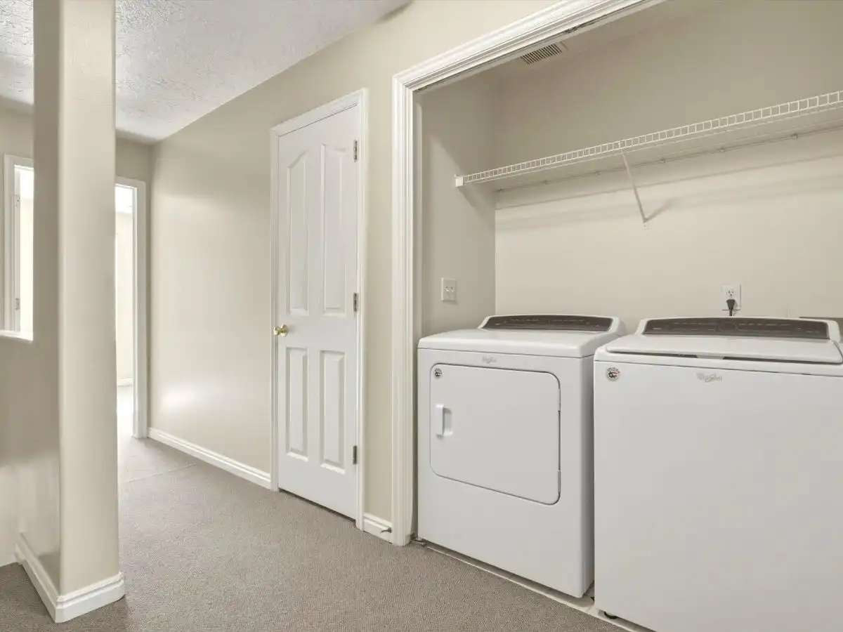 Laundry area in Draper townhome with washer and dryer, hallway access, and practical upper-level layout