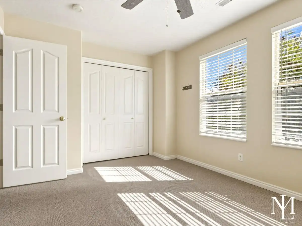 Sunny bedroom in Draper townhome with double closet, large windows, and mountain-area natural light