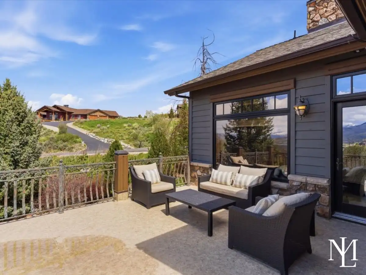 Private outdoor patio with cushioned seating, mountain home exterior, and peaceful foothill surroundings.