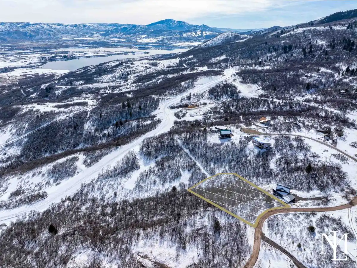 Wooded Eden Utah homesite outlined near Nordic Valley with winter mountain scenery and Pineview Reservoir views in the distance
