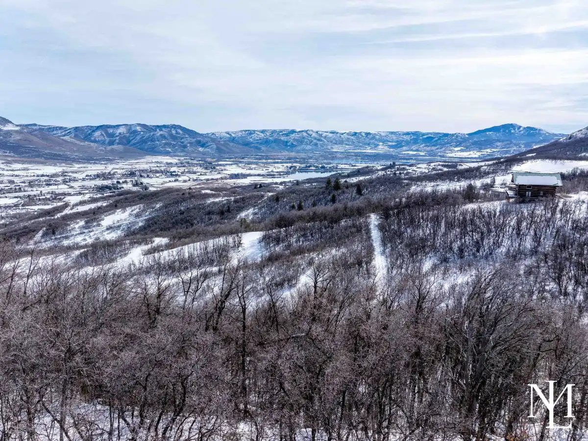 Winter view from wooded Eden Utah land near Nordic Valley overlooking Ogden Valley, Pineview Reservoir, and surrounding mountains