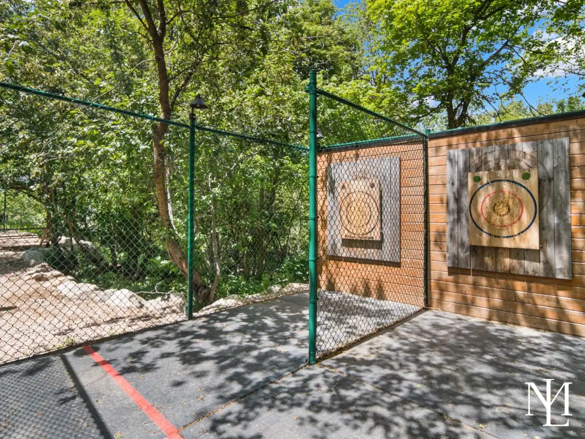 Hatchet throwing area with fenced lanes and wooden targets at a private mountain recreation property.