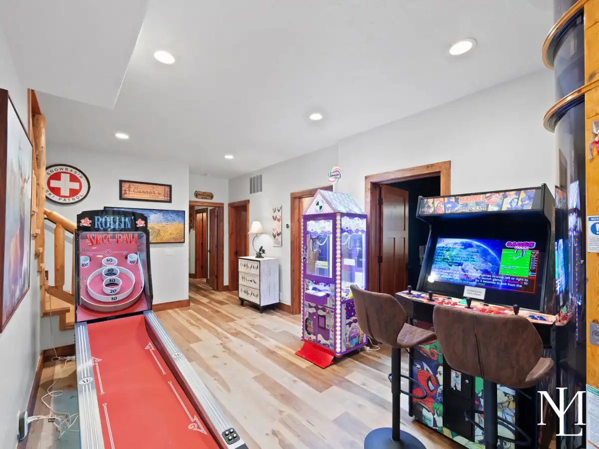 Mountain retreat arcade room with skee-ball, claw machine, and arcade games for family entertainment.