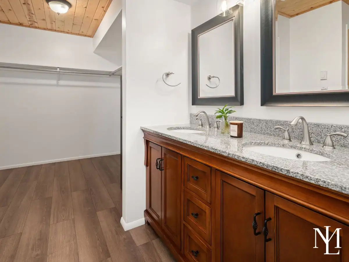 Double vanity bathroom with granite countertops and adjoining walk-in closet in remodeled Eden, Utah residence.