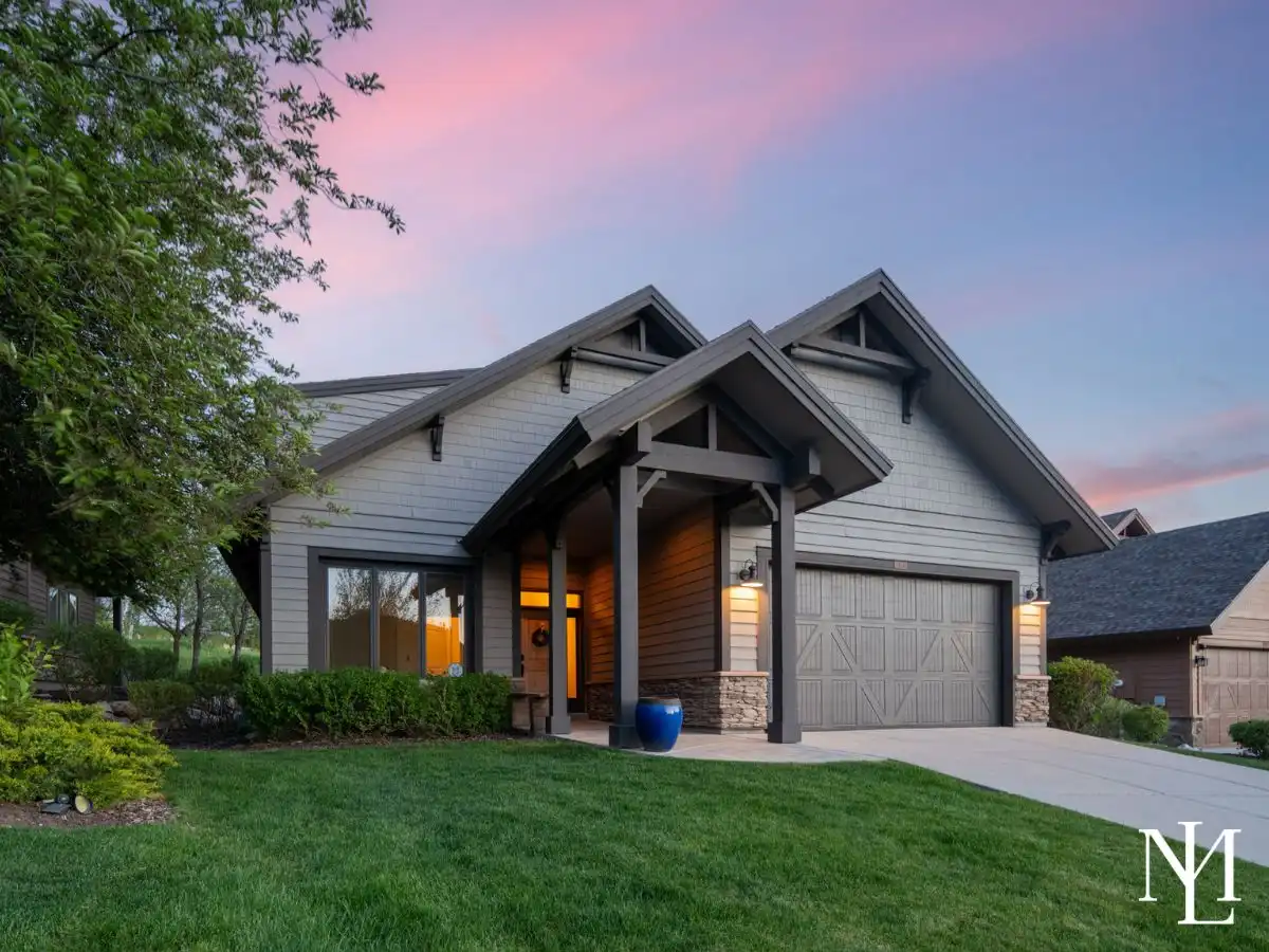 Fully furnished Trapper’s Ridge mountain retreat in Eden Utah with covered front entry, manicured lawn, and sunset sky