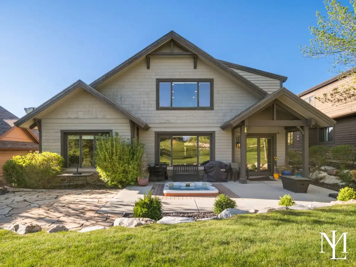 Private patio at Eden Utah mountain retreat with built-in hot tub, outdoor seating, and landscaped yard