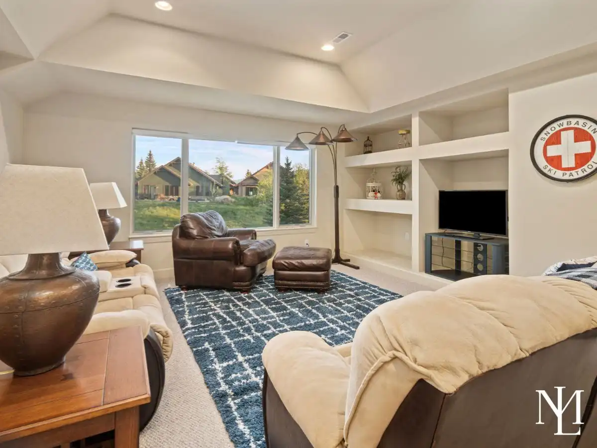 Upper-level family room in Trapper’s Ridge home with vaulted ceiling, built-in shelving, and cozy lounge space