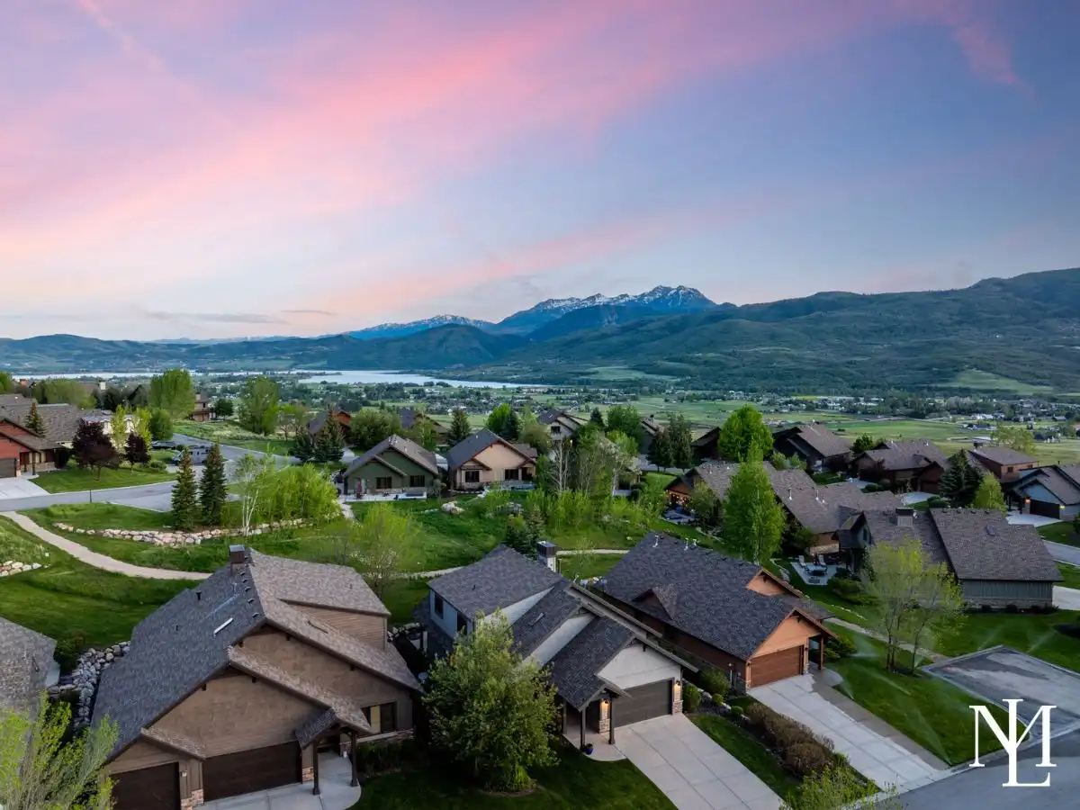 Aerial view of Trapper’s Ridge homes in Eden with Pineview Reservoir, Snowbasin, and Ogden Valley mountain views