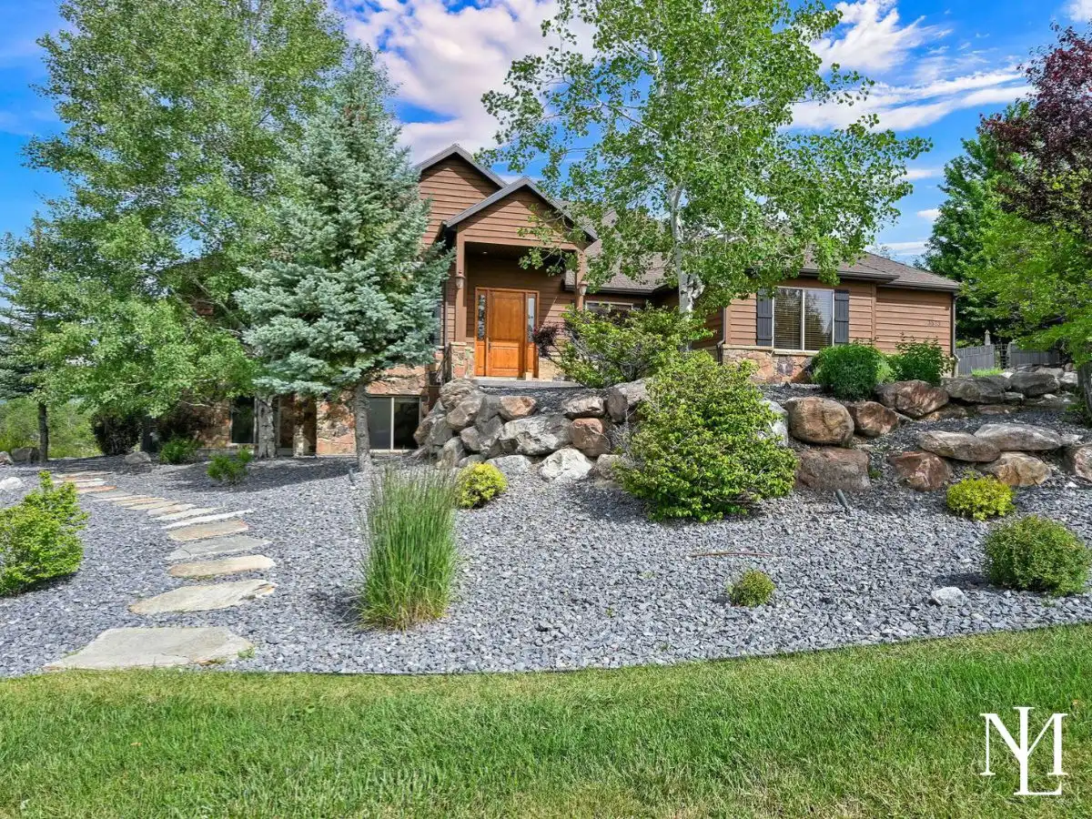 Eden Utah mountain home exterior with mature landscaping, rock retaining walls, and wooded hillside setting
