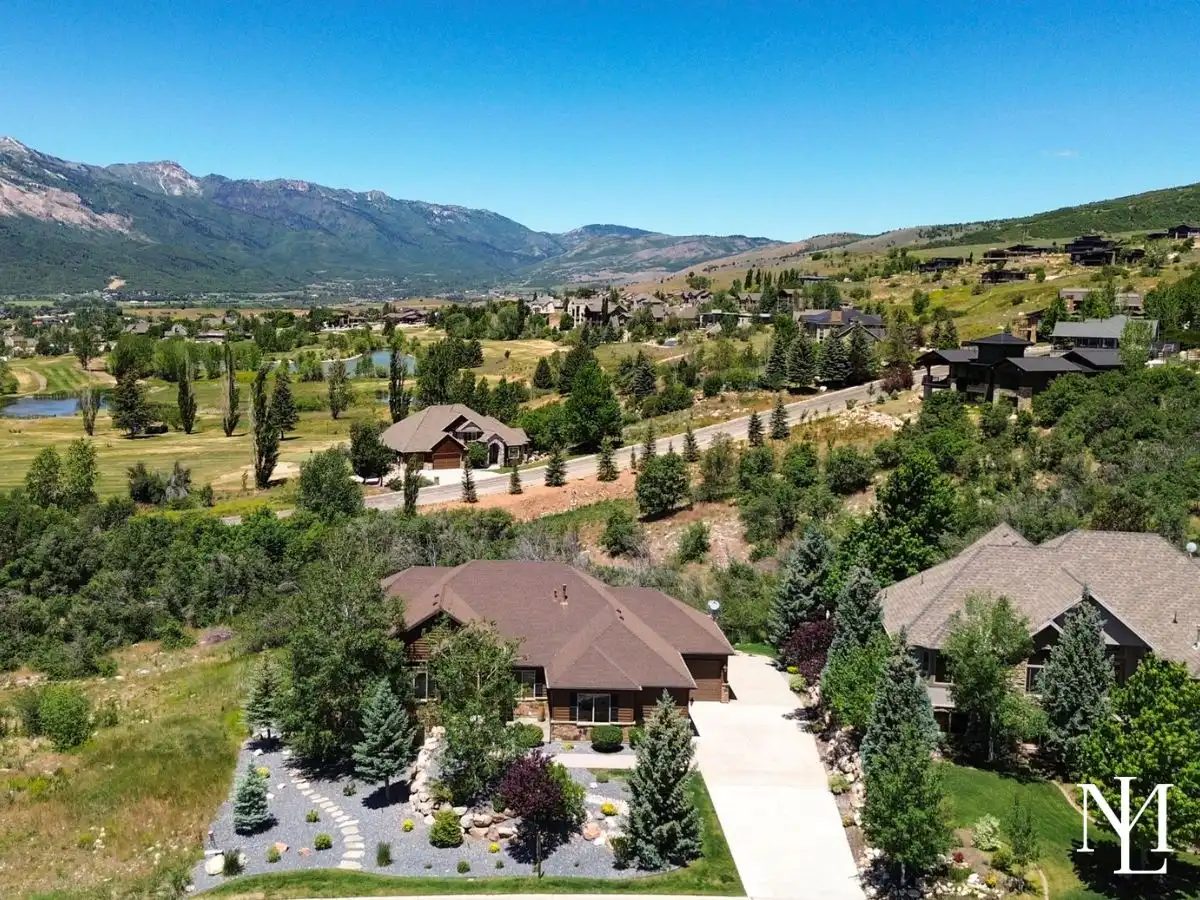 Aerial view of custom Eden Utah home near Wolf Creek Resort with mountain views and mature landscaping