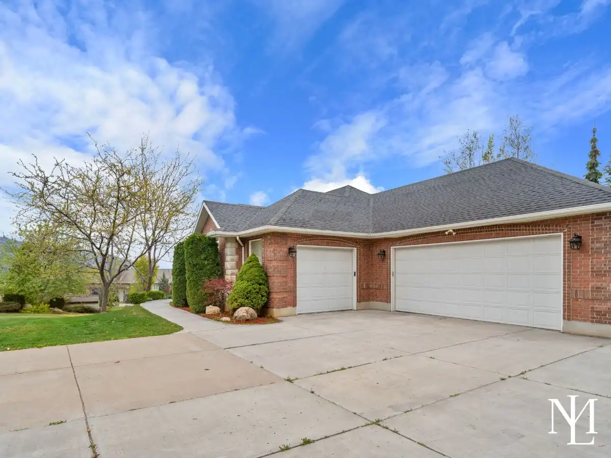 Oversized attached 3-car garage with wide driveway and side entry access.