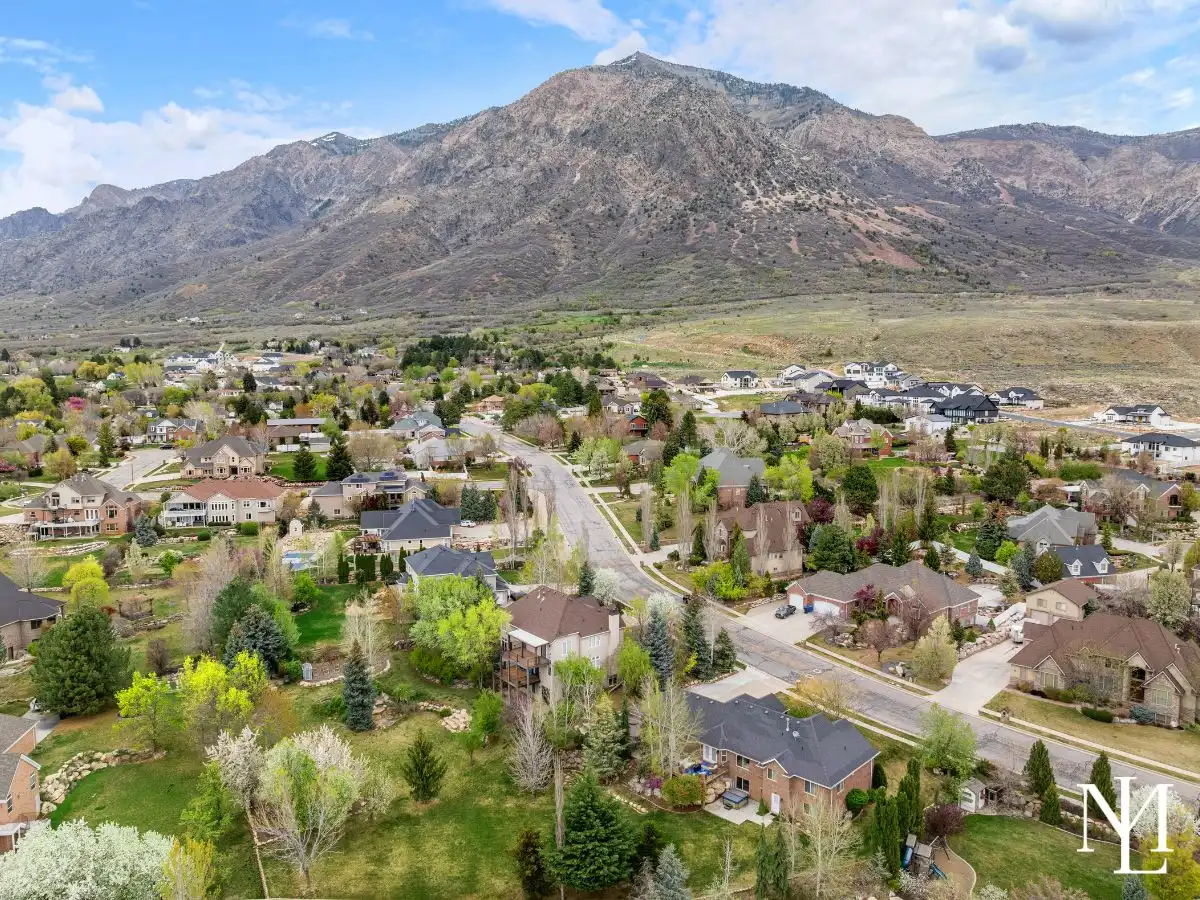 Aerial view of Pleasant View neighborhood with mountain backdrop and surrounding custom homes.