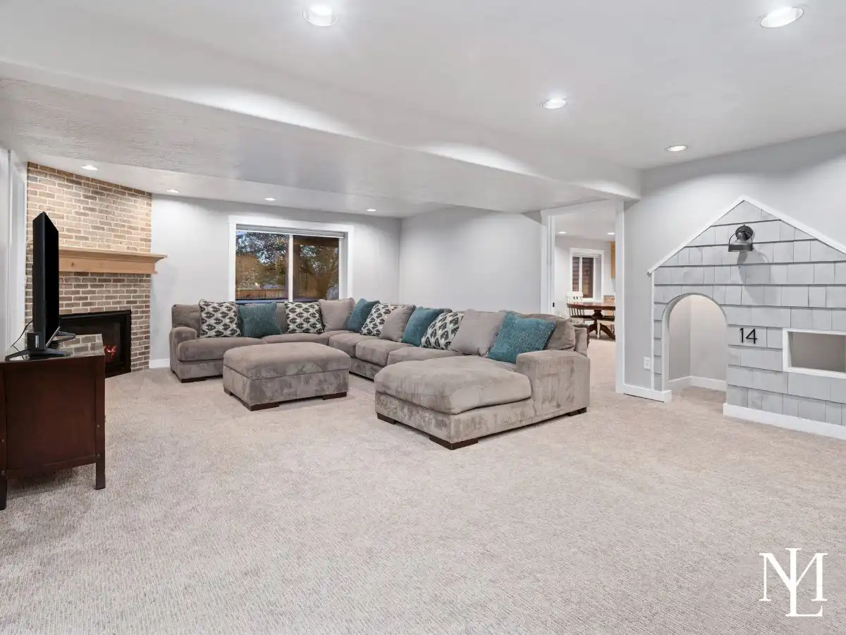 Large finished basement family room with fireplace, built-in playhouse, and open recreation space.