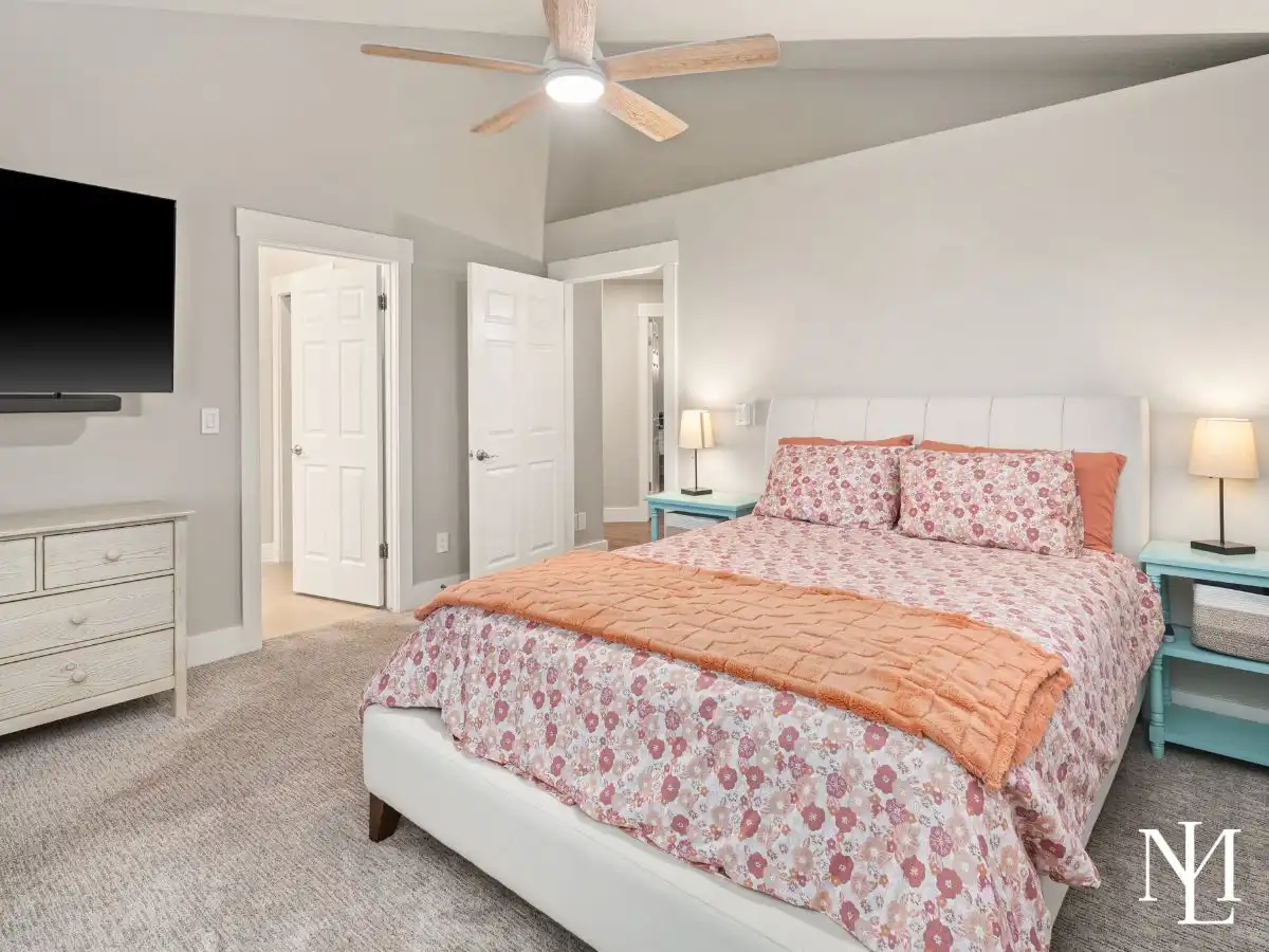 Spacious primary bedroom with vaulted ceiling, neutral finishes, and soft carpet flooring.