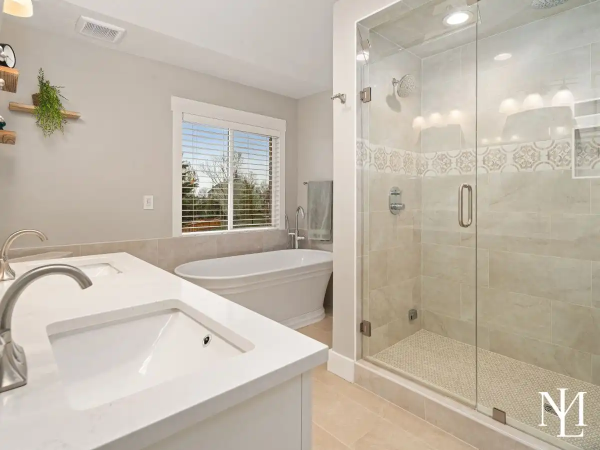 Primary bathroom with freestanding soaking tub, dual-sink vanity, and large glass walk-in shower.