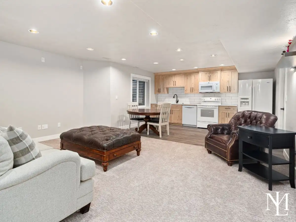 Basement living area with kitchenette, dining nook, recessed lighting, and open lounge space.