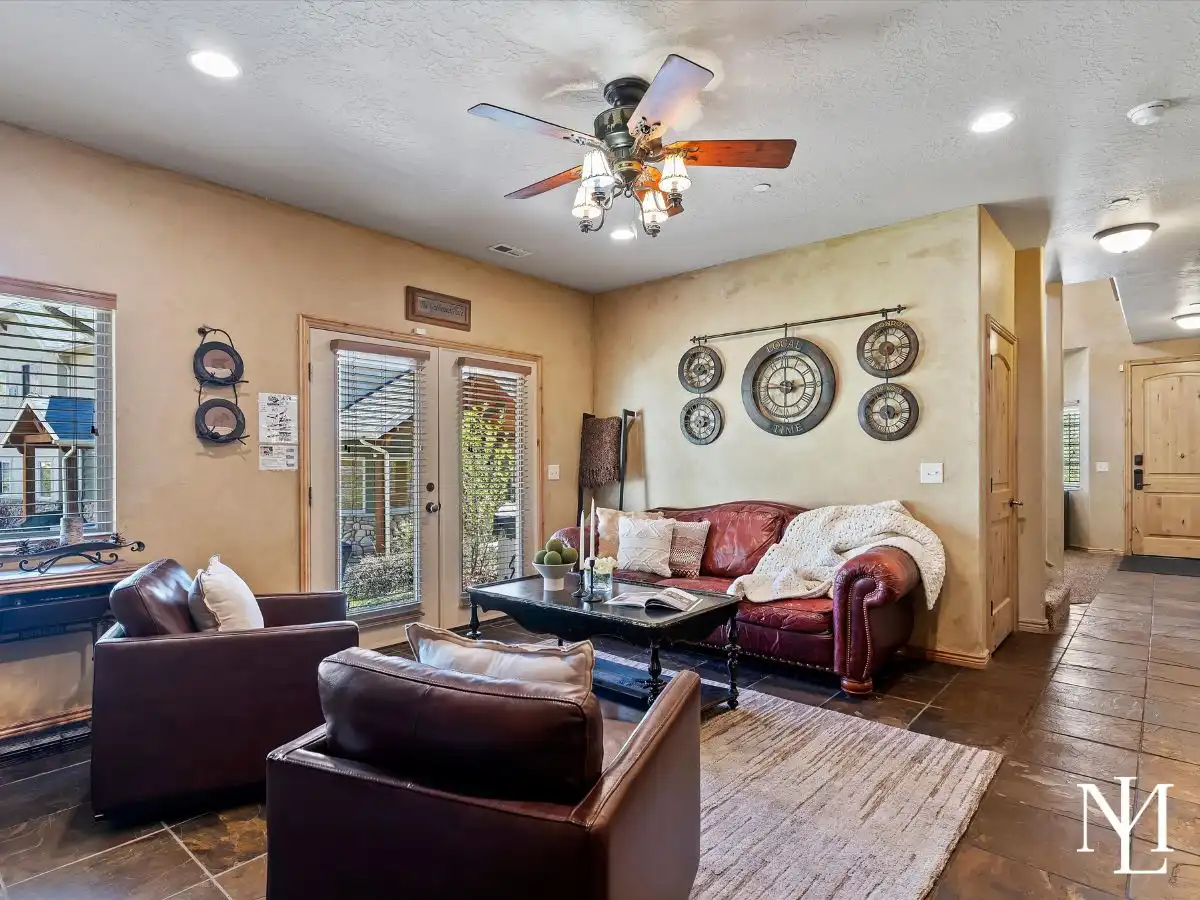 Cozy sitting area with leather seating, slate tile floors, and glass door access in Eden, Utah townhome.