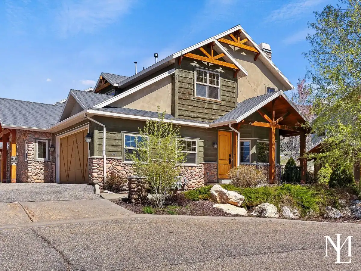 Mountain-style townhome exterior in Eden, Utah with timber gable accents, stone detailing, and covered front entry in the Wolf Creek area.