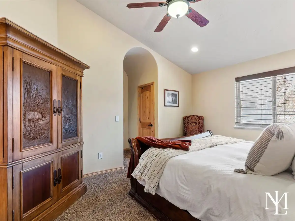 Inviting bedroom with rich wood furniture, soft natural light, and warm mountain-town style in Eden, Utah.