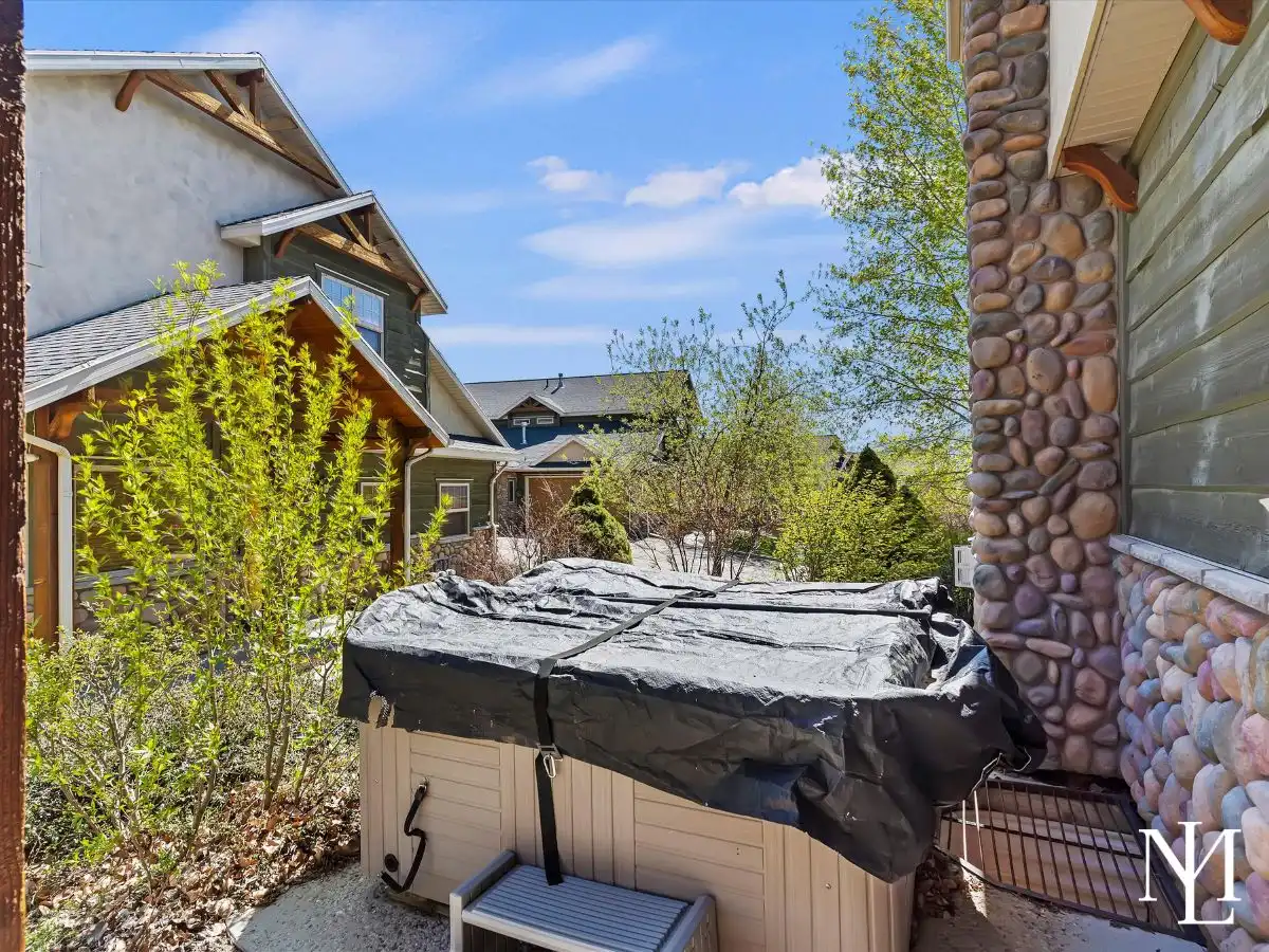 Private hot tub beside stone exterior wall in Wolf Creek townhome in Eden, Utah near year-round recreation.
