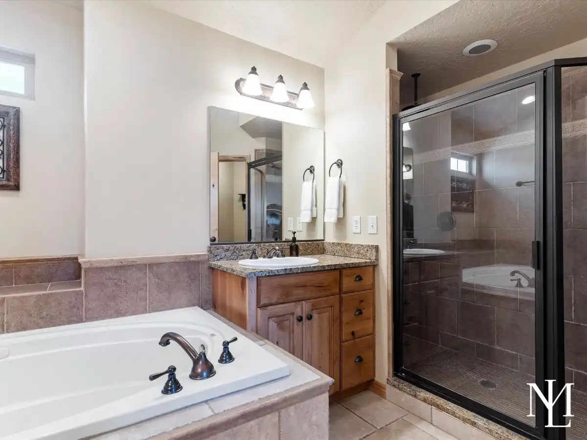 Primary bathroom with soaking tub, granite vanity, and glass walk-in shower in mountain townhome in Eden, Utah.