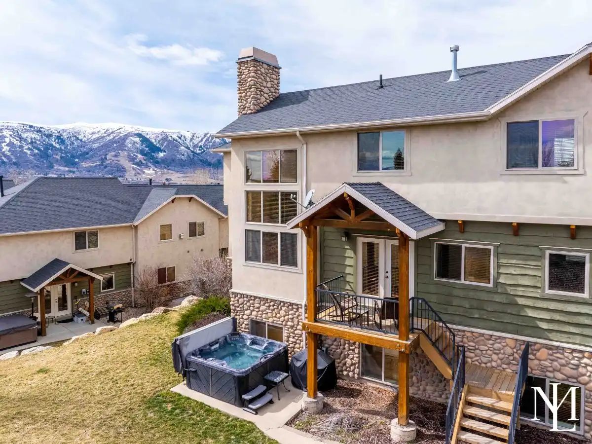 Townhome exterior with private hot tub, balcony, and mountain views in Eden, Utah near Wolf Creek Resort.