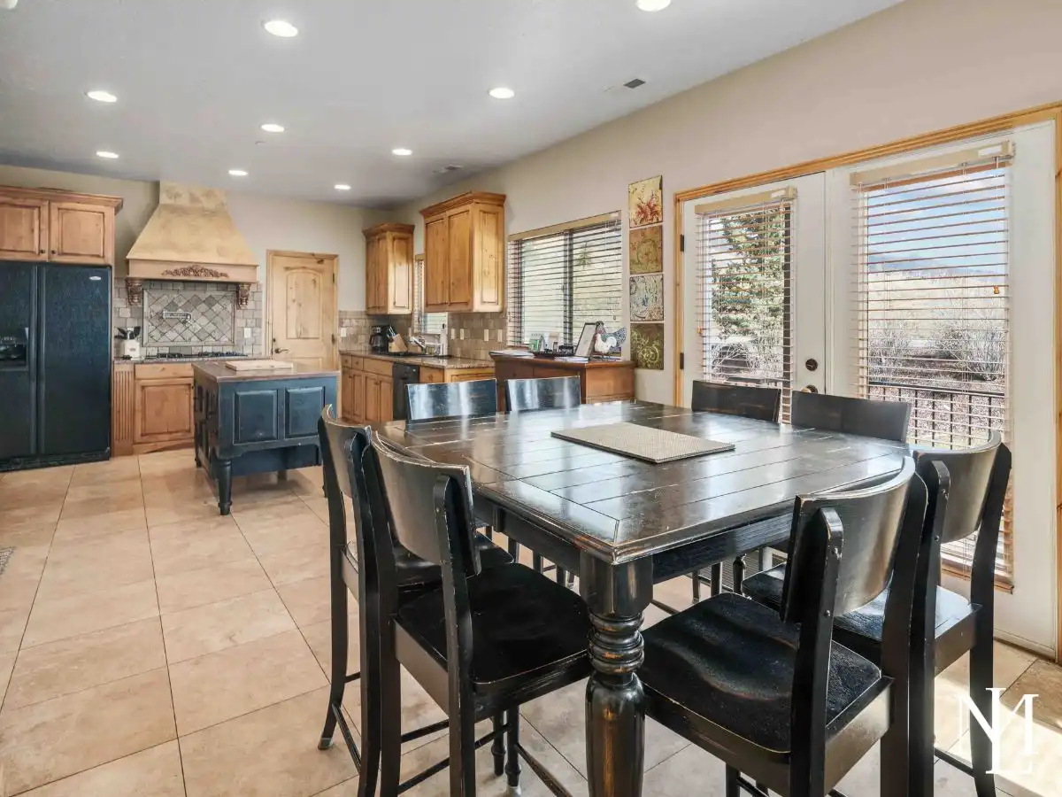 Dining area with large table and open flow into the kitchen, bright natural light, Eden, Utah townhouse.