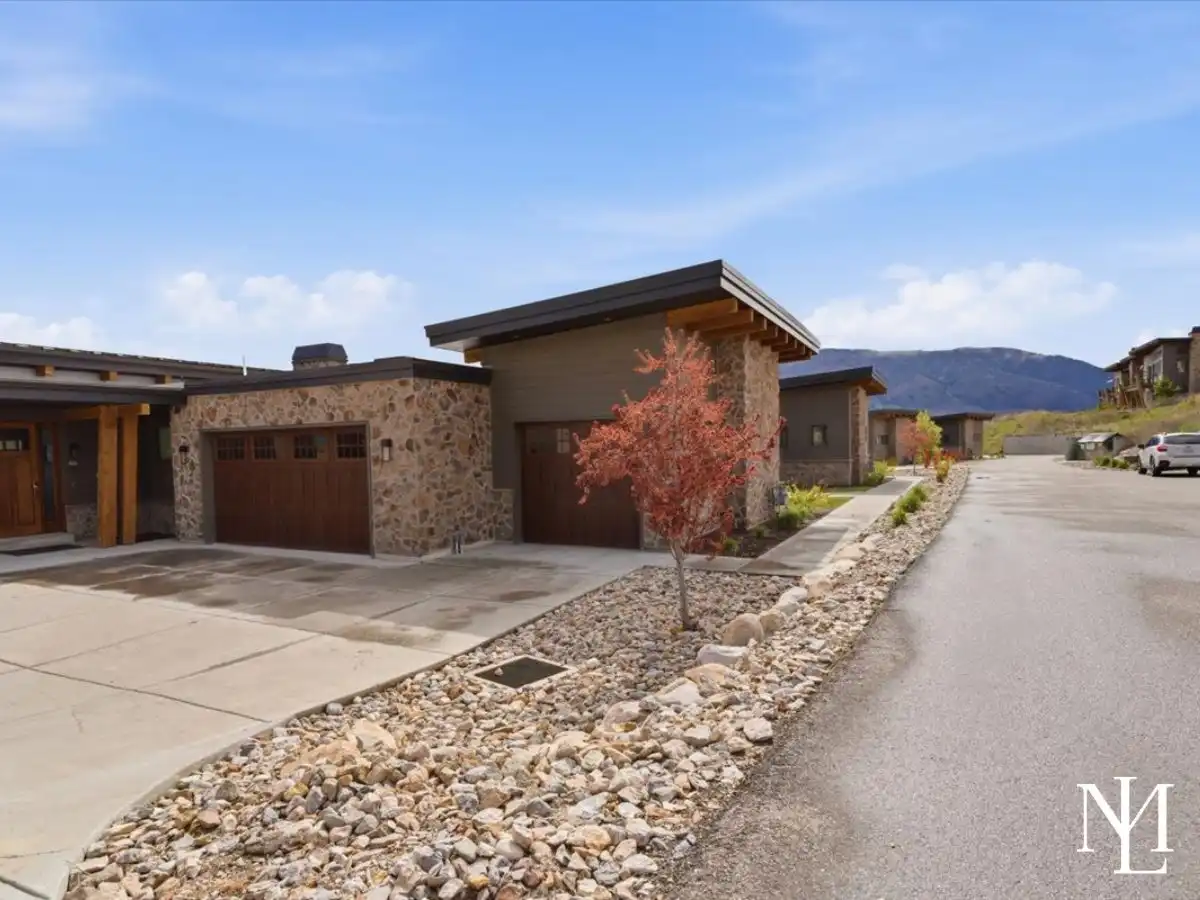 Eden, Utah townhome exterior with stone accents, garage, mountain backdrop, and landscaped entry
