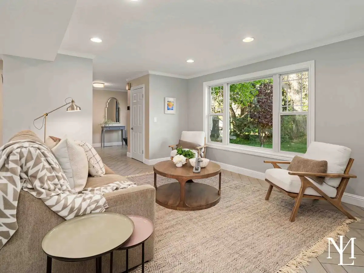 Cozy sitting room with neutral finishes, soft natural light, picture window, and an inviting layout for reading or conversation.