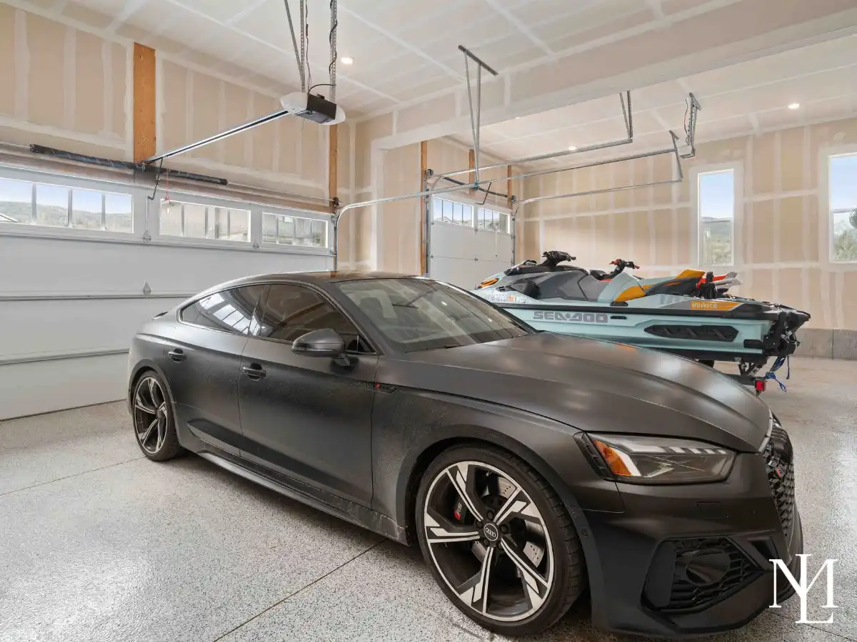 Oversized garage with a black car and jet skis