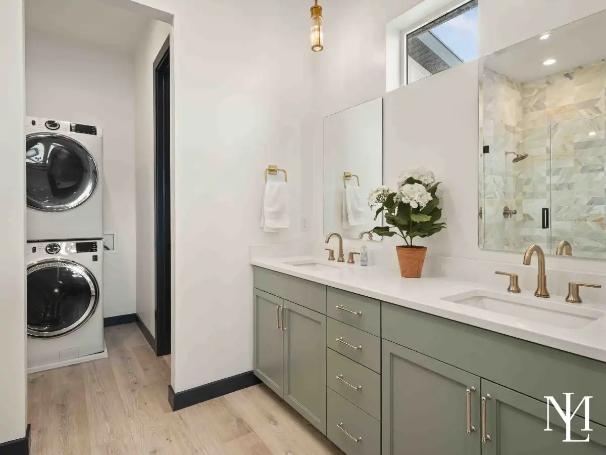Primary bathroom with double sinks, elegant finishes, and dedicated laundry area.