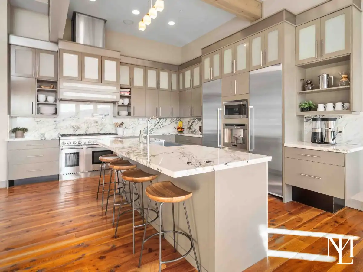 Chef’s kitchen with marble countertops, oversized island, custom cabinetry, and high-end appliances in luxury Huntsville residence.