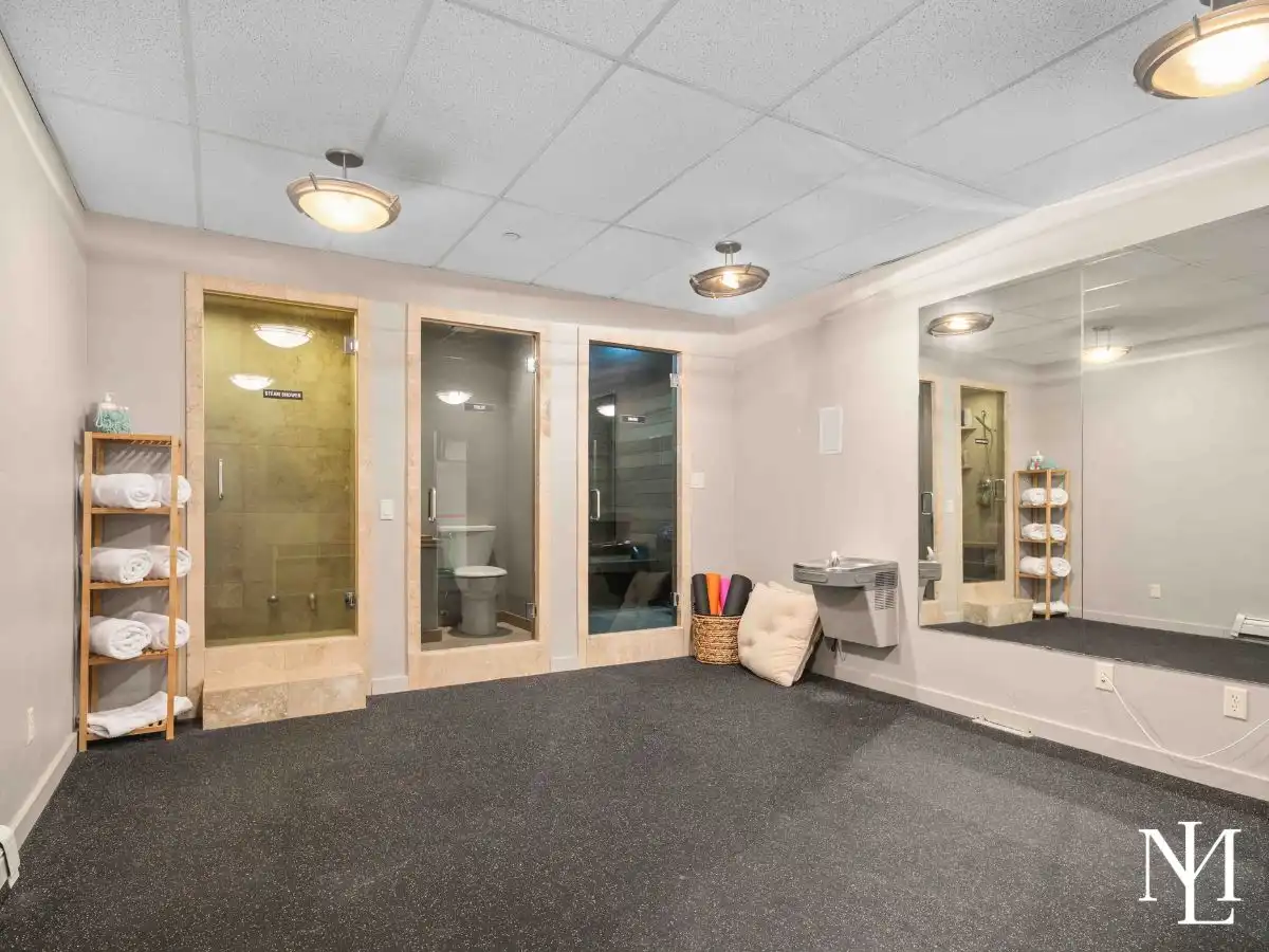 Wellness retreat with mirrored exercise space, steam shower, and spa amenities in custom Huntsville mountain residence.