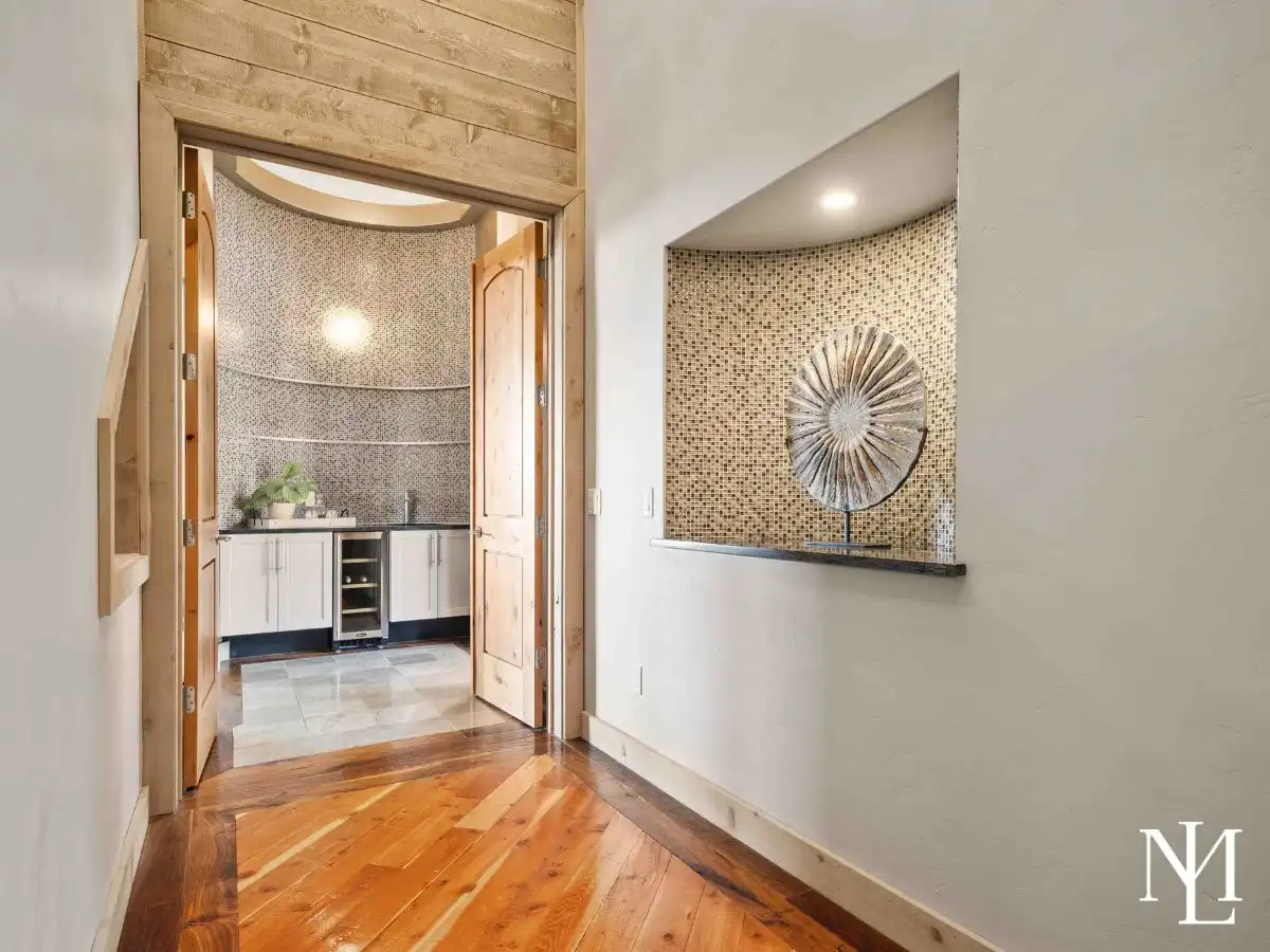 Hallway leading to wet bar area with mosaic wall detail and refined finishes in luxury Huntsville mountain home.
