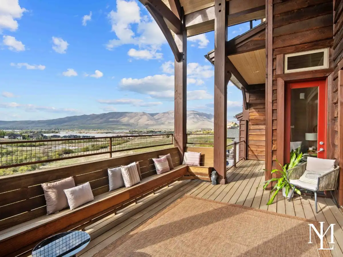 Covered deck with built-in bench seating and expansive views of Pineview Reservoir and the surrounding mountains in Huntsville, Utah.