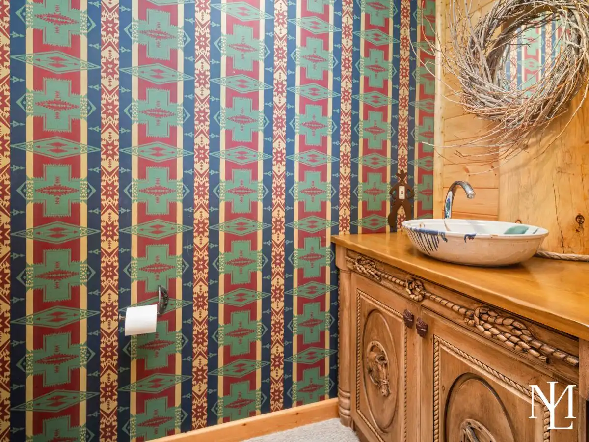 Powder bath with Southwestern patterned wallpaper and vessel sink vanity in a mountain home.
