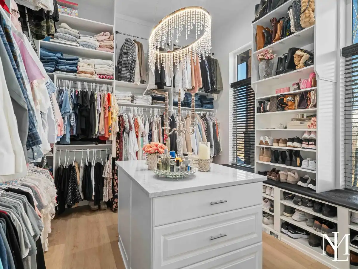 Large walk-in closet with custom shelving, center island, and natural light.