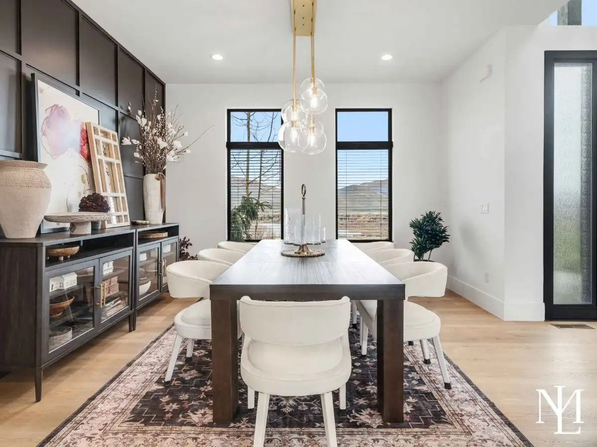 Formal dining room with modern chandelier, mountain views, and wood flooring.