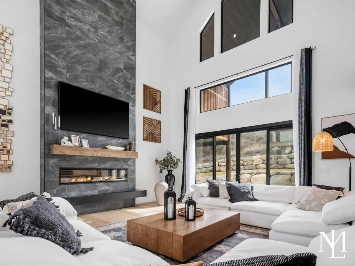 Great room with soaring ceilings, floor-to-ceiling fireplace, and large windows.