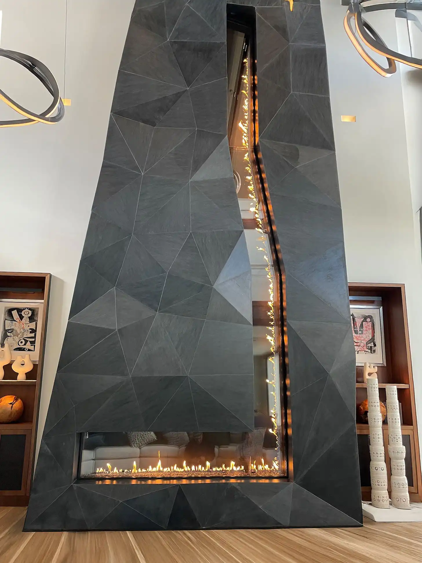 A two-story fireplace with undulating contemporary panels.