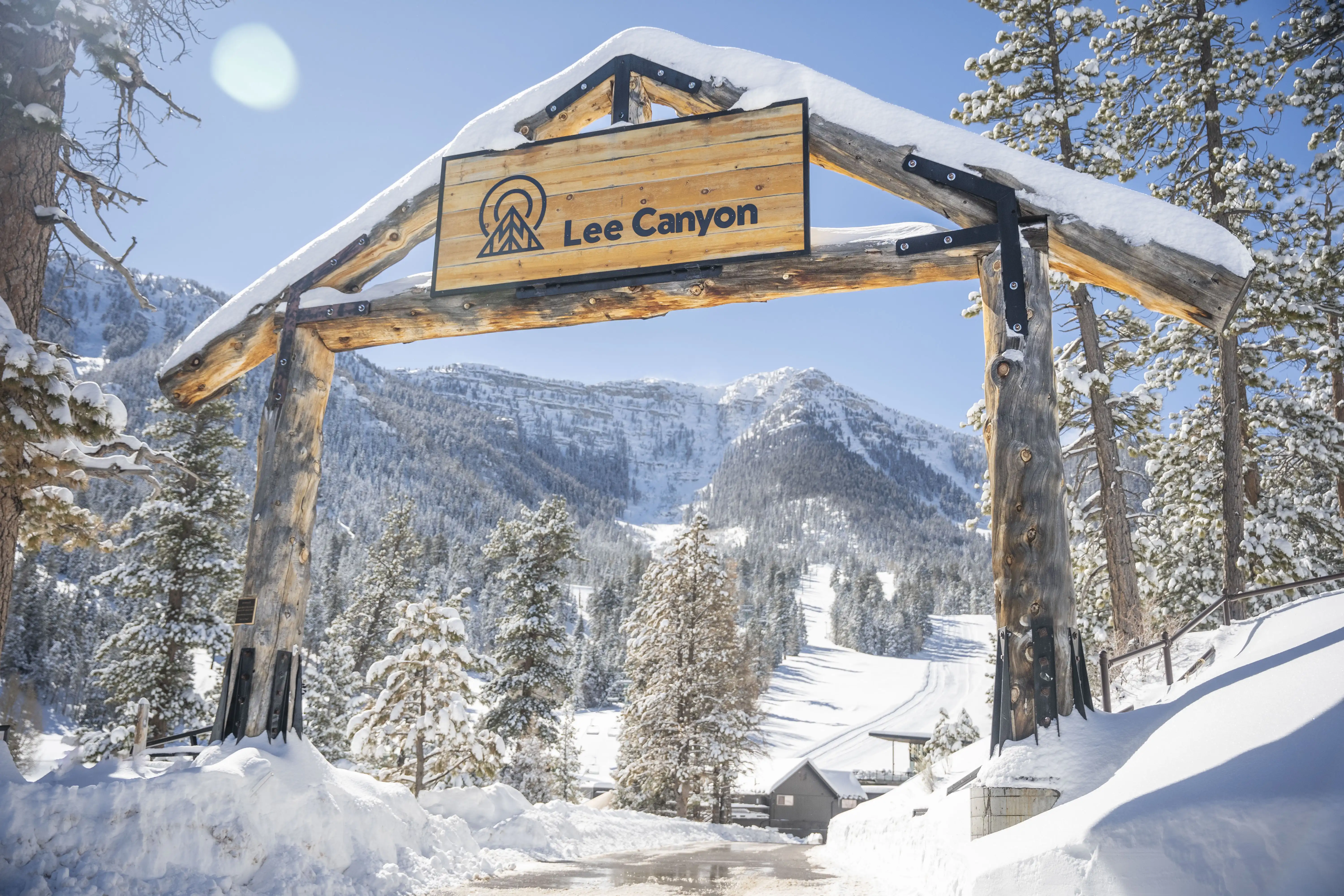 Entry sign to Lee Canyon covered in snow.