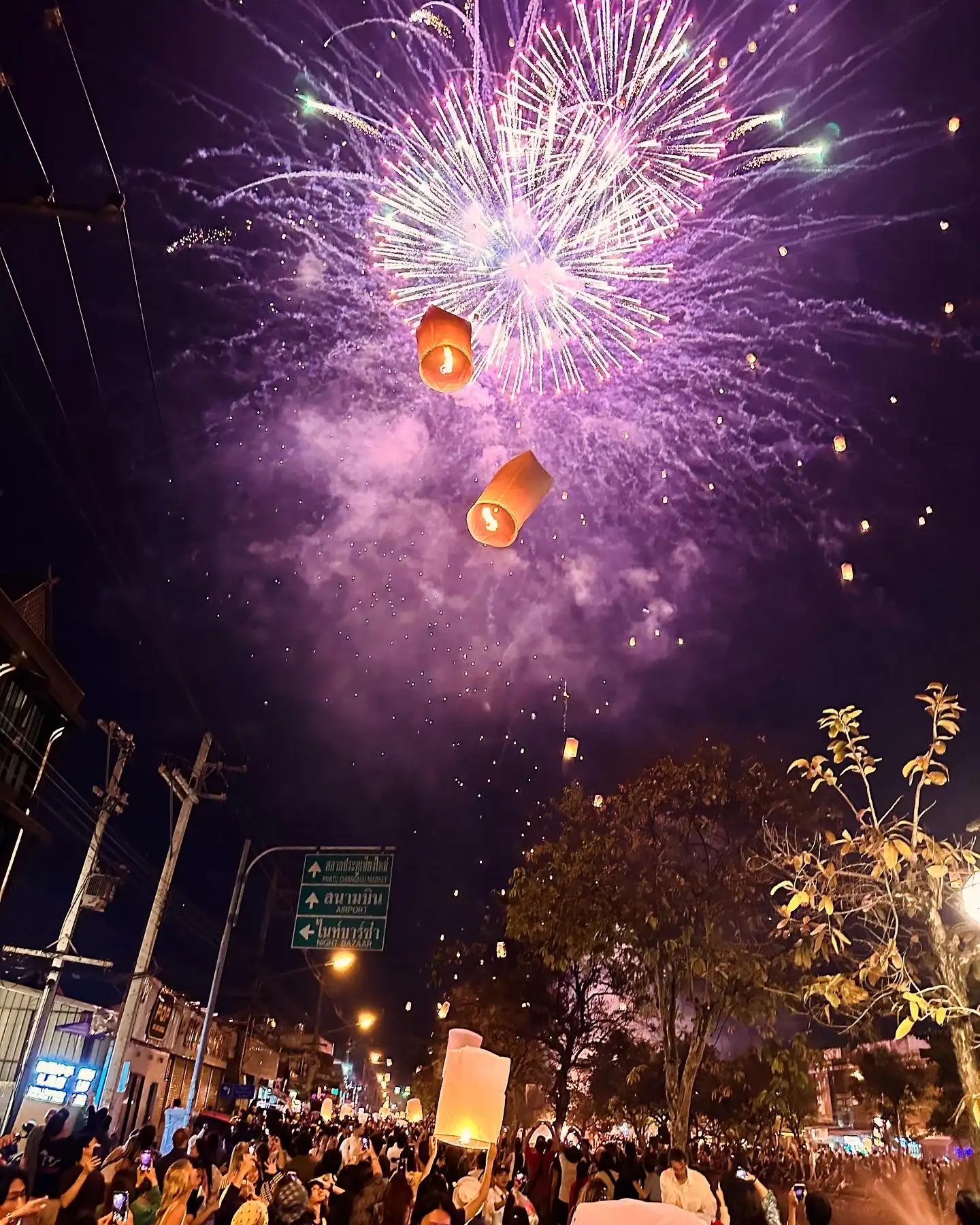 Thailand paper lanterns with fireworks in the background.