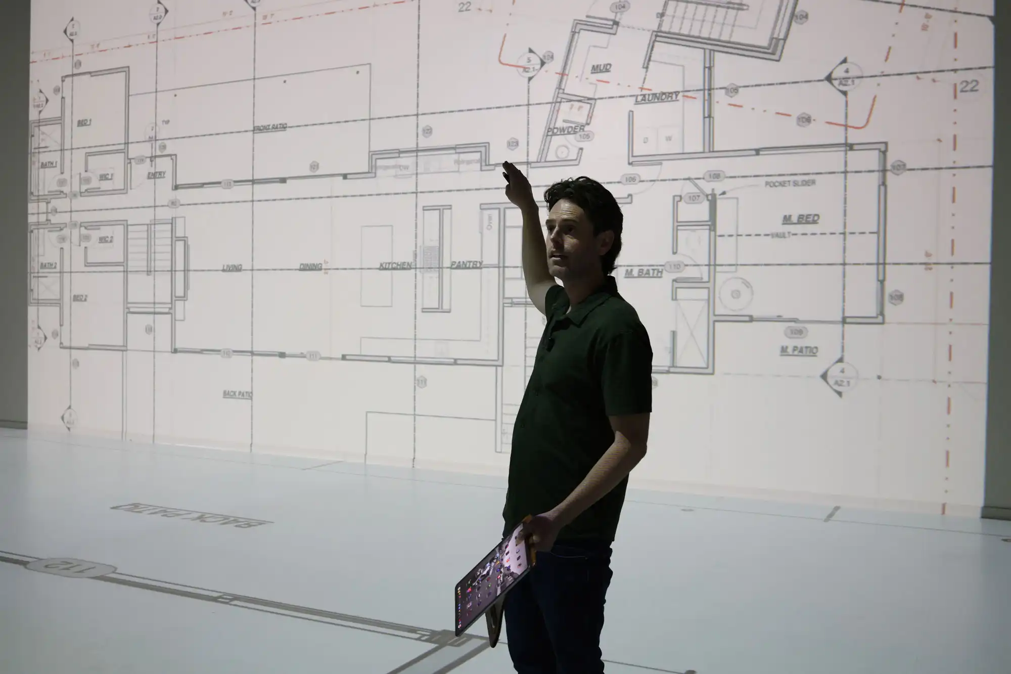Man presenting custom home floor plans during an architectural design walkthrough