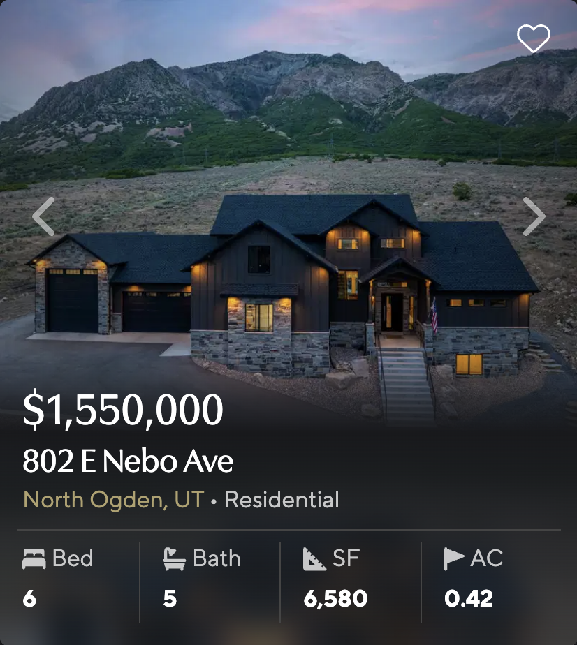 Two-story home at 802 E Nebo Ave in North Ogden, Utah, illuminated at dusk with mountain hillside behind it