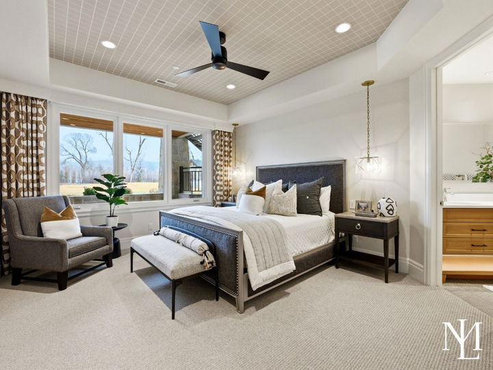 Stylish guest bedroom with large window, designer lighting, and adjoining bath in luxury Huntsville Utah home.