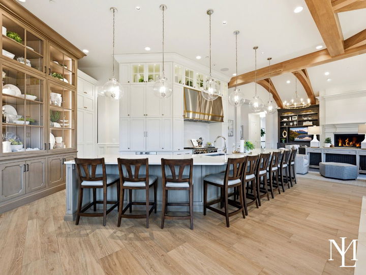 Oversized chef’s kitchen with long island seating, custom cabinetry, glass pendant lights, and open connection to great room.