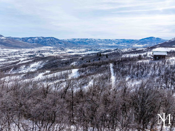 Winter view from wooded Eden Utah land near Nordic Valley overlooking Ogden Valley, Pineview Reservoir, and surrounding mountains